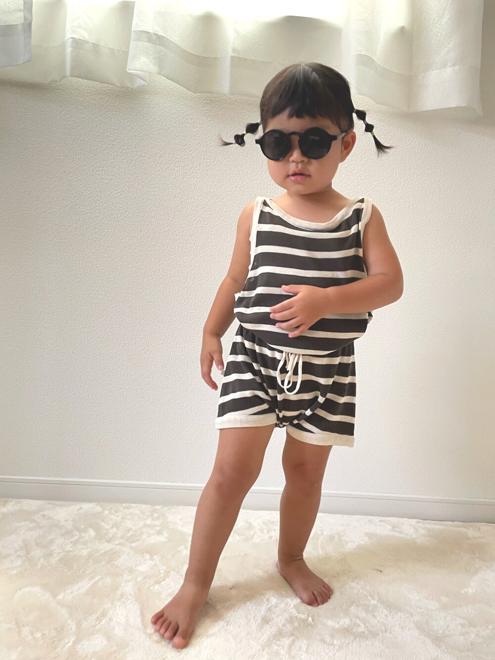 グレー系のタンクトップ、グレー系のその他パンツ、ブラック系のサングラスを着用したキッズの夏コーディネートの3枚目の写真