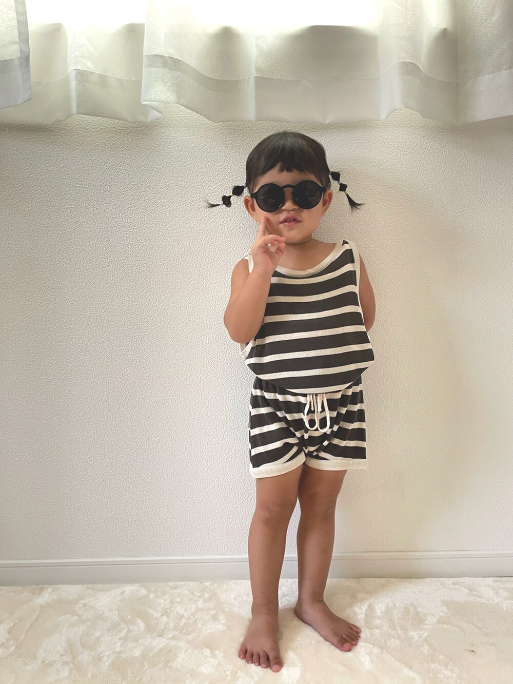 グレー系のタンクトップ、グレー系のその他パンツ、ブラック系のサングラスを着用したキッズの夏コーディネートの2枚目の写真