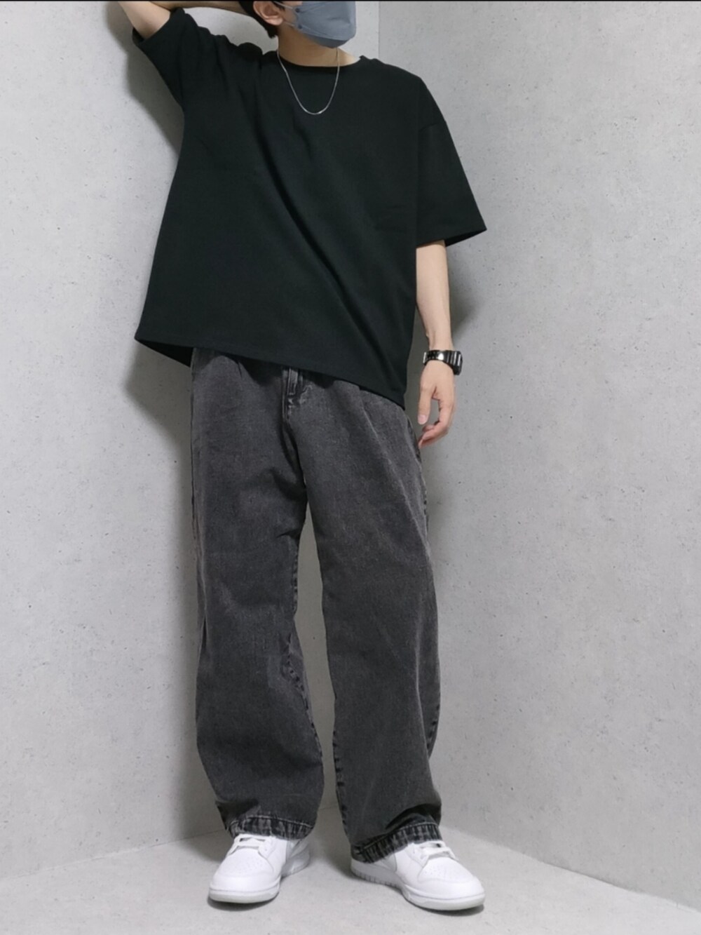 ブラック系のデニムパンツ、ホワイト系のスニーカー、ブラック系のTシャツ/カットソーを着用したメンズの夏コーディネートの2枚目の写真