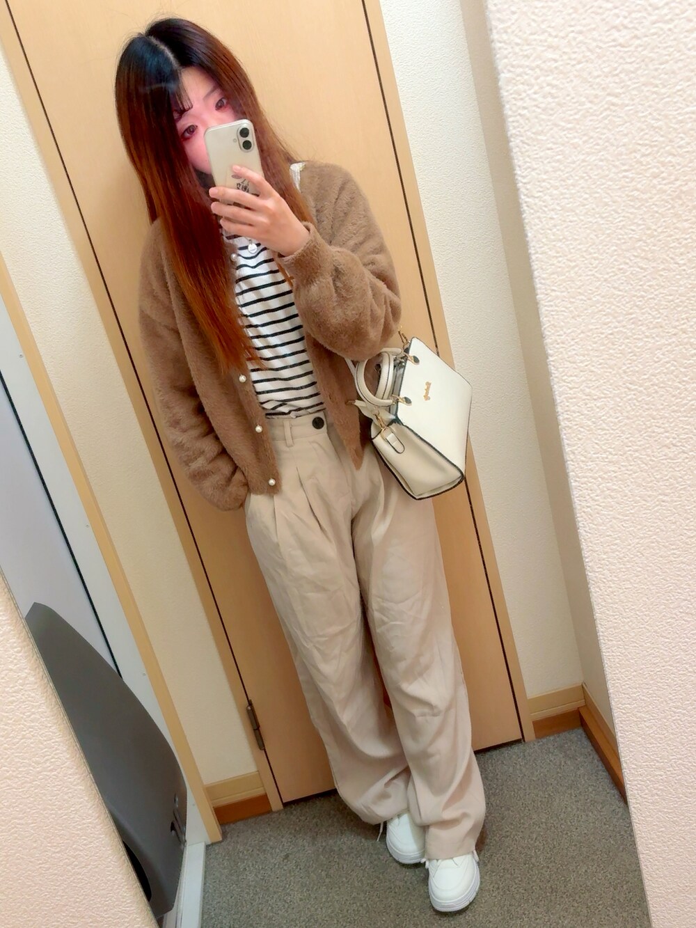 ホワイト系のシューズを着用したレディースの秋コーディネートの2枚目の写真