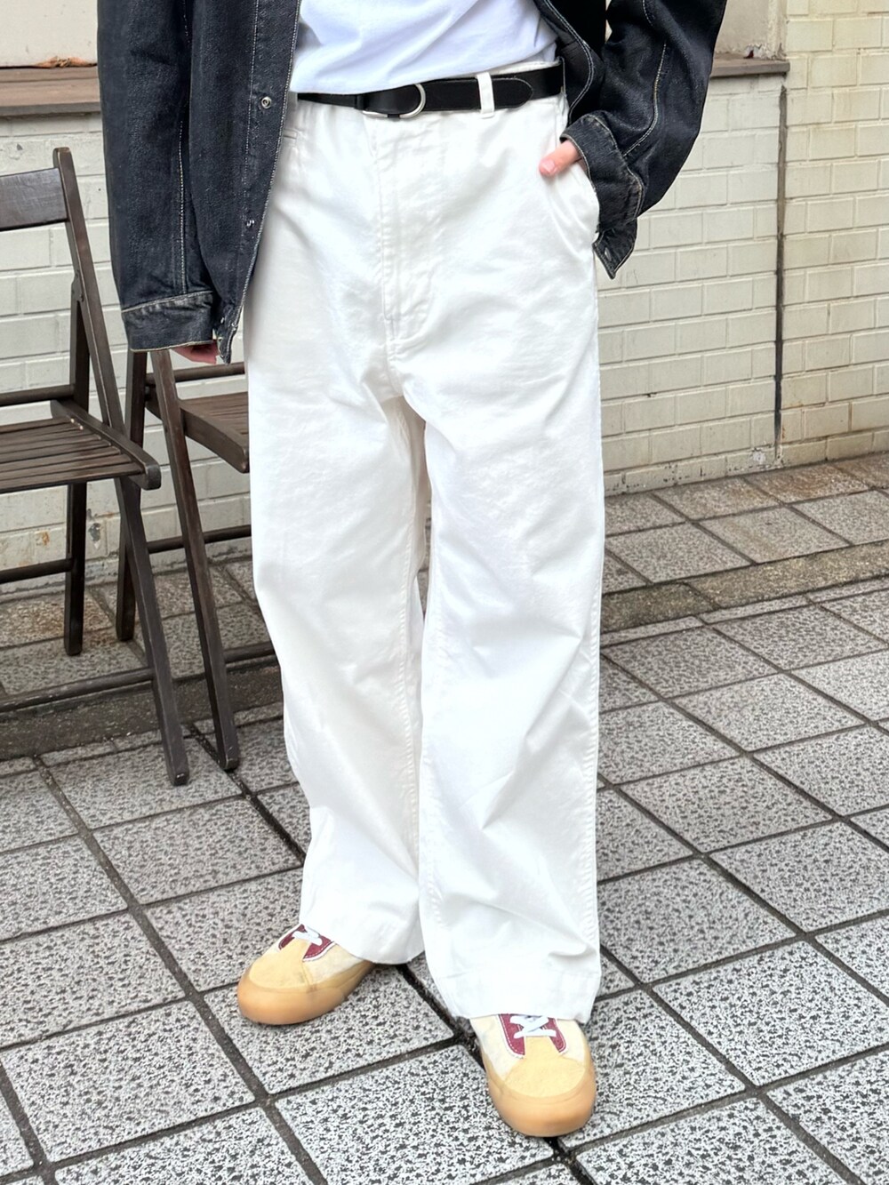 ブラック系のデニムジャケット、ホワイト系のチノパンツ、レッド系のキャップを着用したメンズの冬コーディネートの3枚目の写真