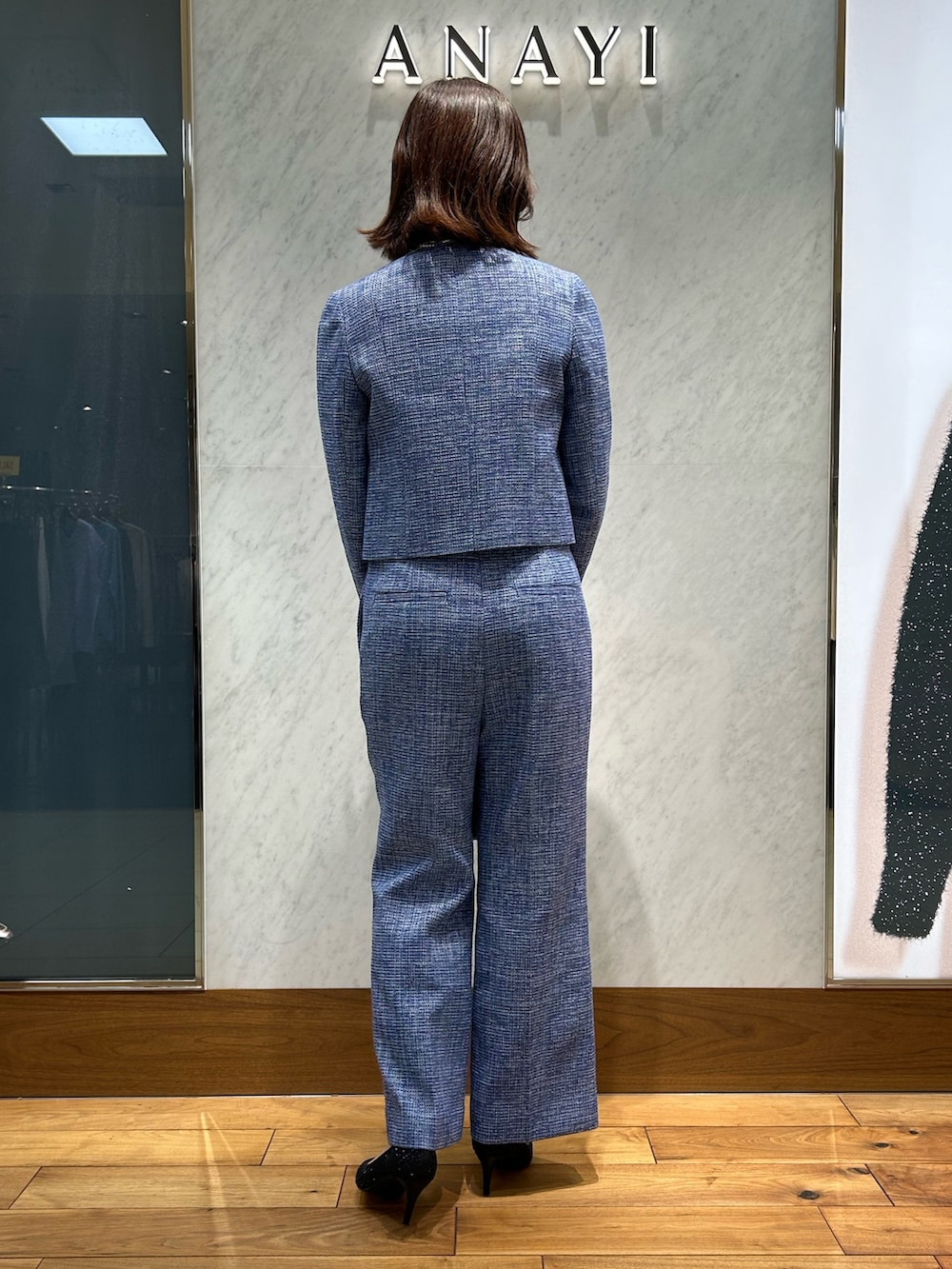 ホワイト系のニット/セーター、ブルー系のトートバッグ、ブルー系のノーカラージャケットを着用したレディースの冬コーディネートの3枚目の写真
