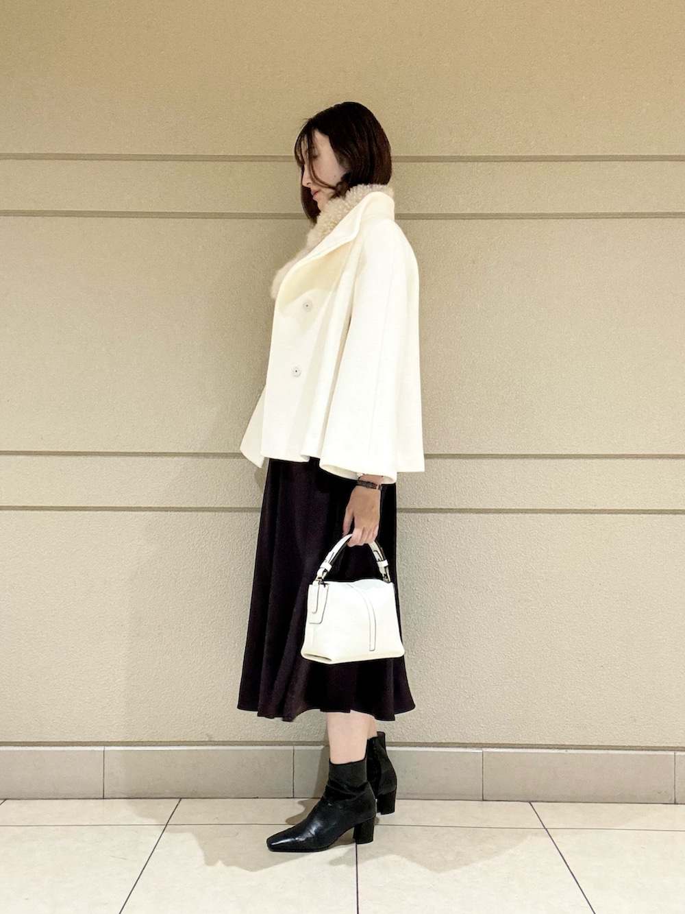 ベージュ系のシャツ/ブラウス、ホワイト系のショルダーバッグ、ホワイト系のその他アウターを着用したレディースの冬コーディネートの2枚目の写真