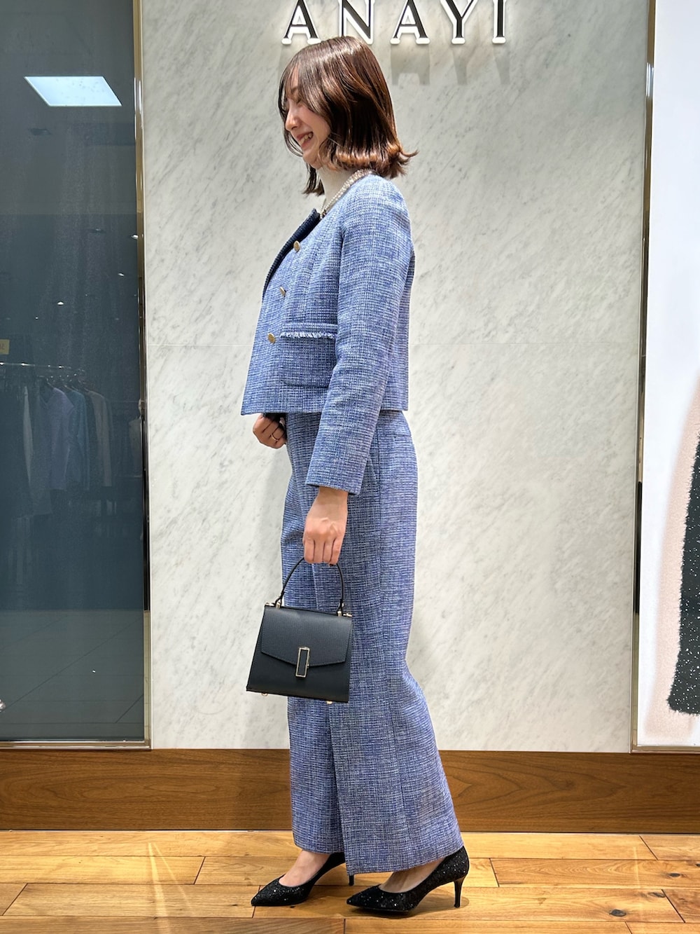 ホワイト系のニット/セーター、ブルー系のトートバッグ、ブルー系のノーカラージャケットを着用したレディースの冬コーディネートの2枚目の写真