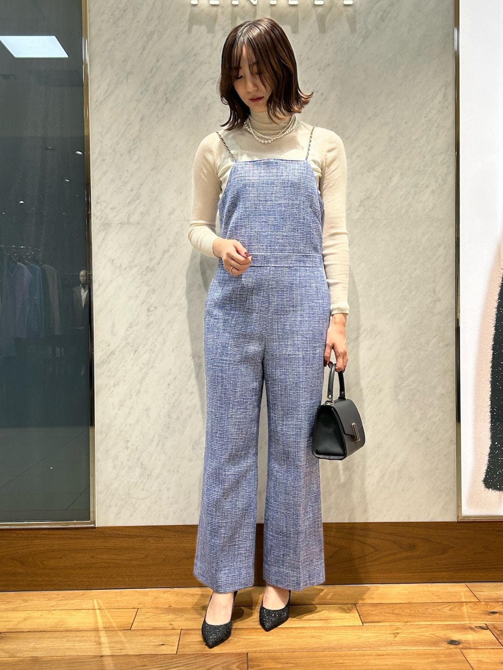 ホワイト系のニット/セーター、ブルー系のトートバッグ、ブルー系のノーカラージャケットを着用したレディースの冬コーディネートの5枚目の写真