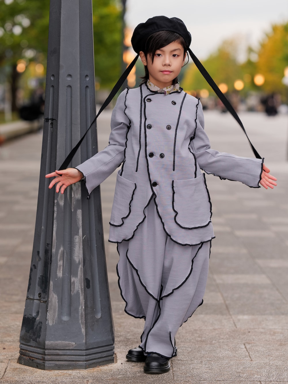 グレー系のジャケット/アウター、グレー系のその他パンツ、ブラック系のローファーを着用したキッズの冬コーディネートの5枚目の写真