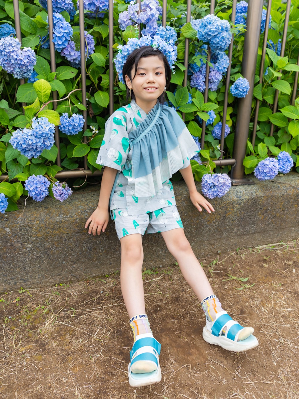 ブルー系のサンダル、ベージュ系の帽子、ブルー系の付け襟を着用したキッズの夏コーディネートの3枚目の写真
