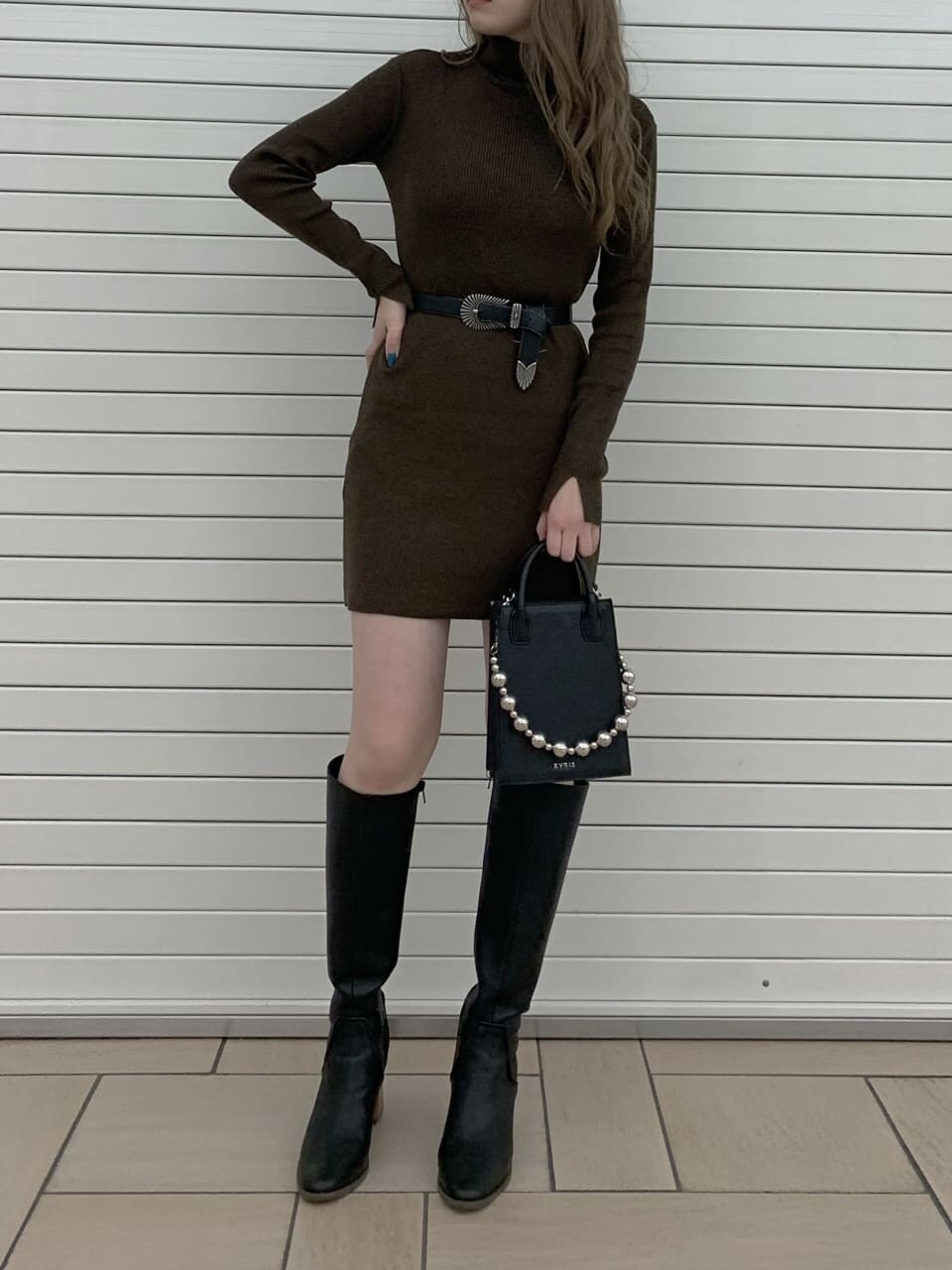 ブラウン系のワンピース、ブラック系のブルゾン、ブラック系のブーツを着用したレディースの秋コーディネートの2枚目の写真