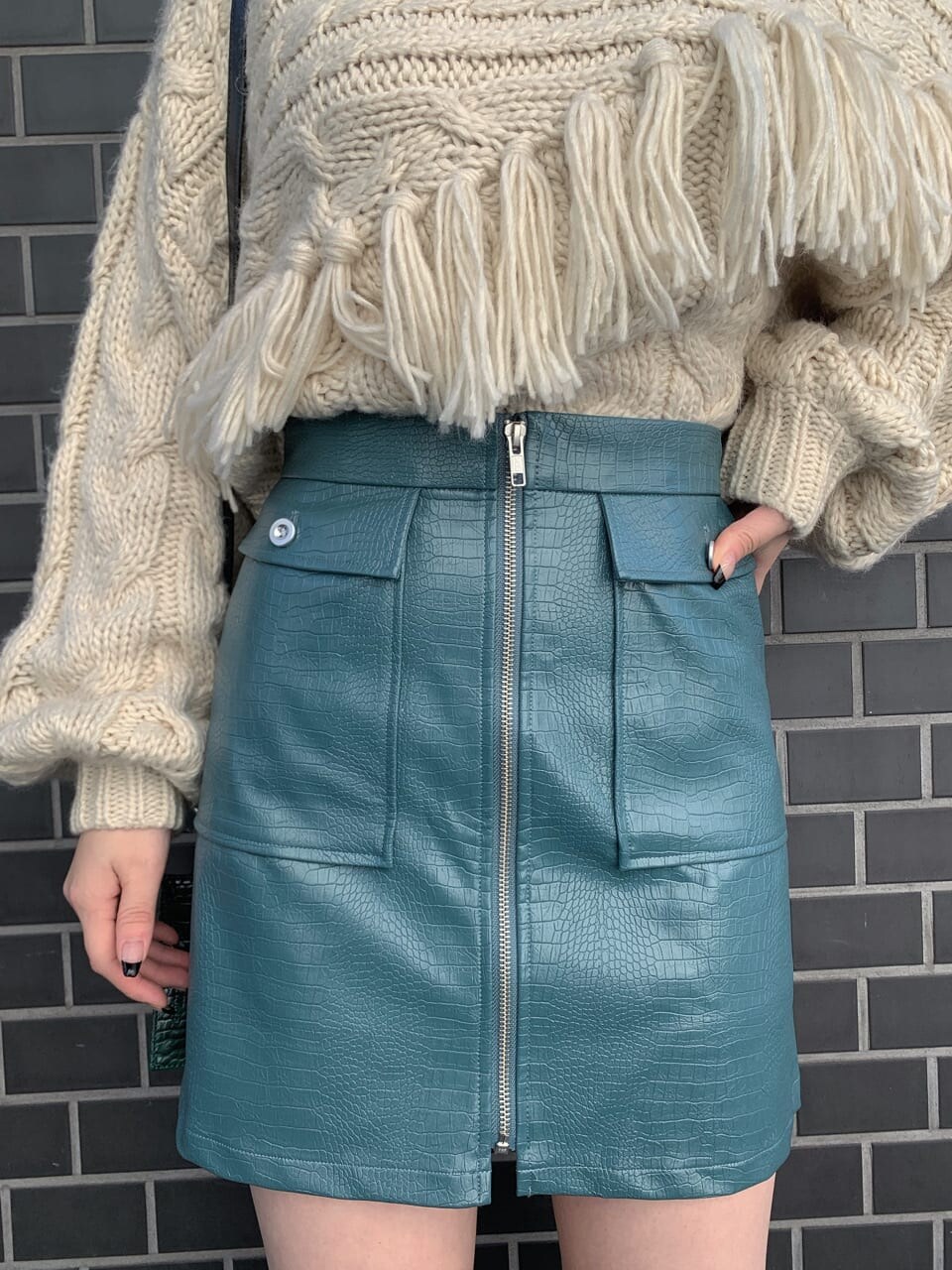 ブラック系のブーツ、ブラック系のショルダーバッグ、ホワイト系のニット/セーターを着用したレディースの秋コーディネートの3枚目の写真