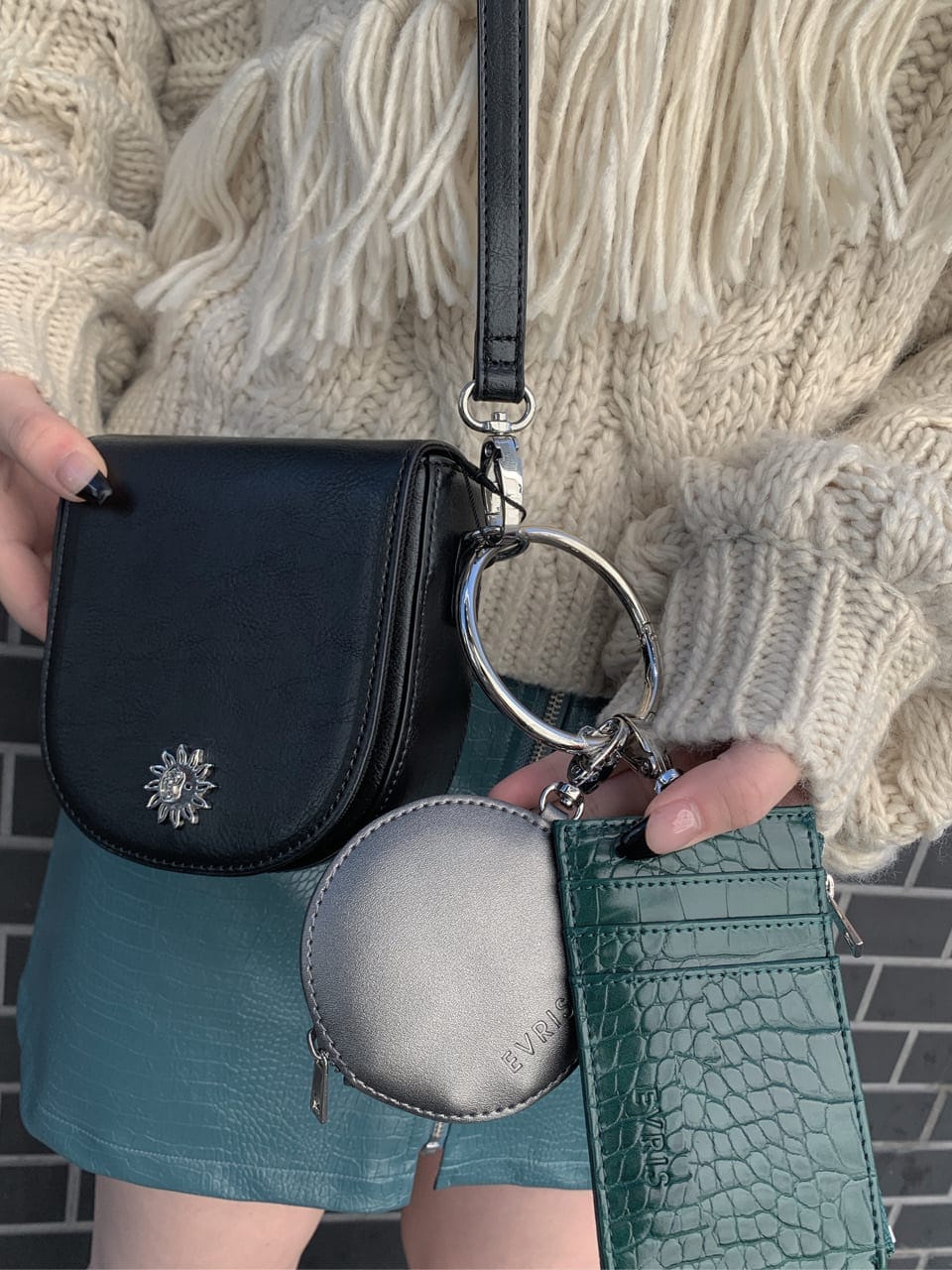 ブラック系のブーツ、ブラック系のショルダーバッグ、ホワイト系のニット/セーターを着用したレディースの秋コーディネートの5枚目の写真