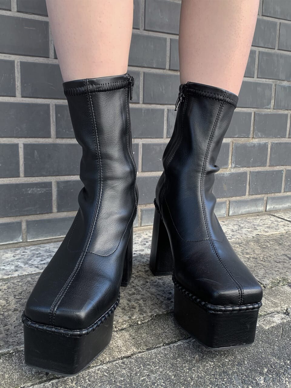 ブラック系のブーツ、ブラック系のショルダーバッグ、ホワイト系のニット/セーターを着用したレディースの秋コーディネートの6枚目の写真