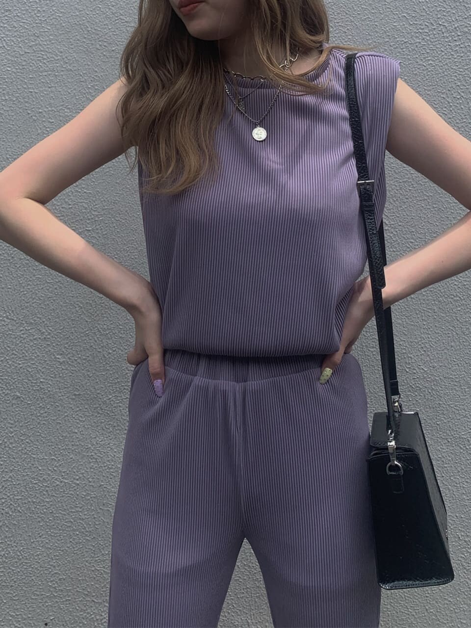 ブラック系のサンダル、パープル系のTシャツ/カットソー、パープル系のスラックスを着用したレディースの夏コーディネートの2枚目の写真