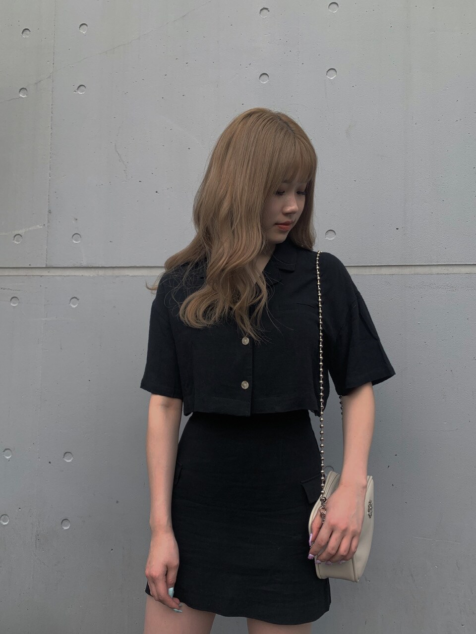 ブラック系のサンダル、ブラック系のスカートを着用したレディースの春コーディネートの2枚目の写真