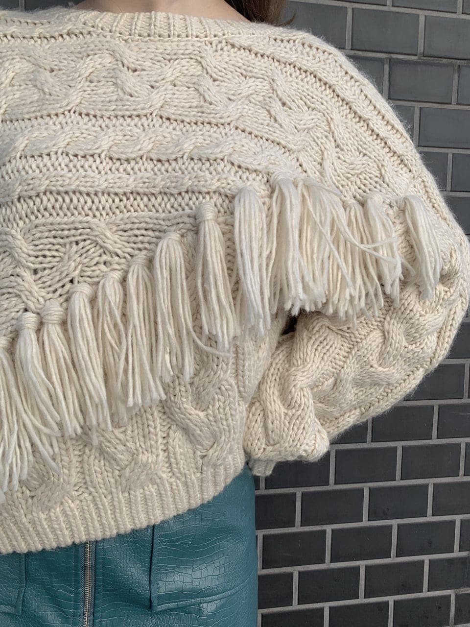 ブラック系のブーツ、ブラック系のショルダーバッグ、ホワイト系のニット/セーターを着用したレディースの秋コーディネートの4枚目の写真