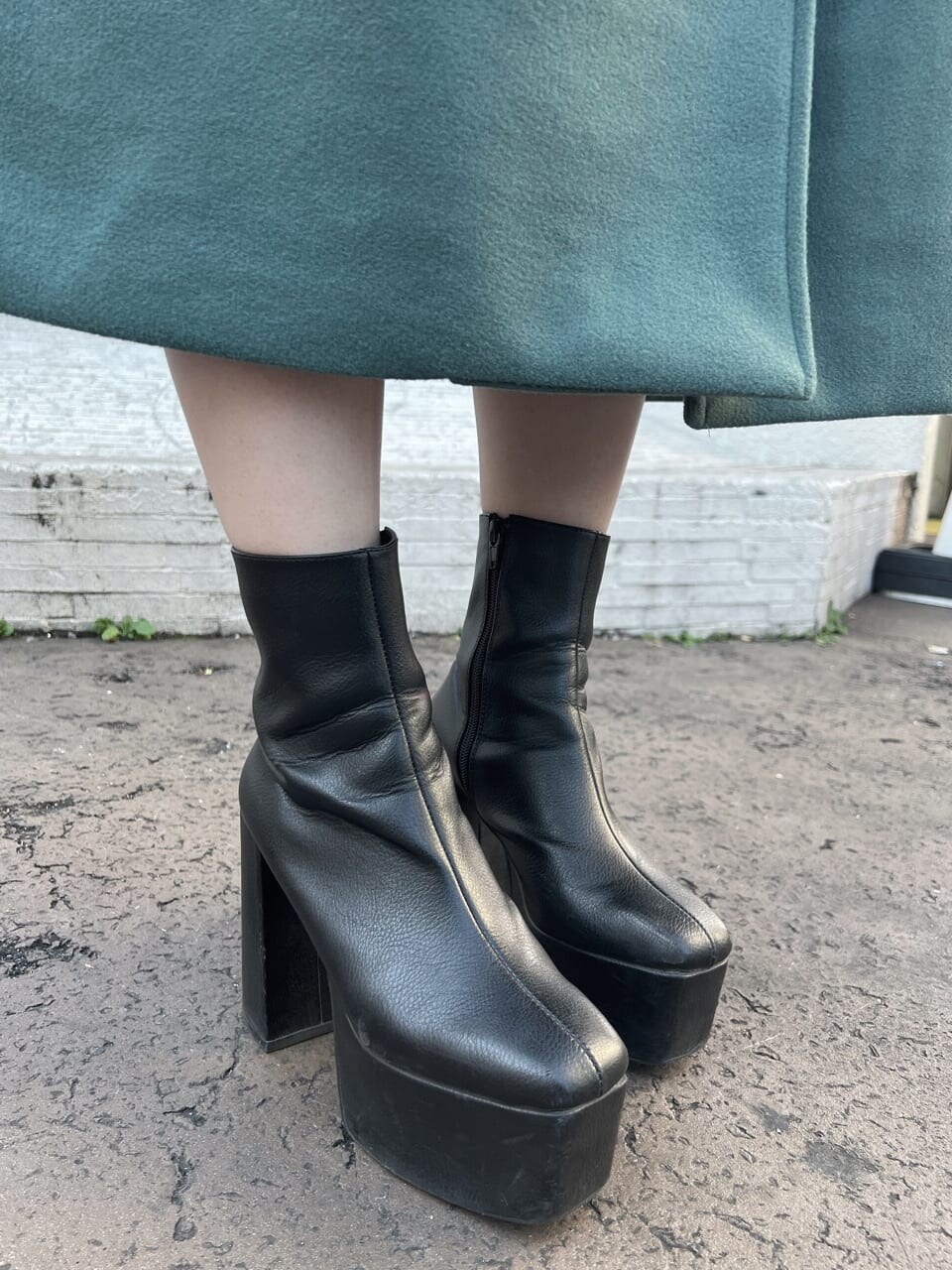 ブラック系のショルダーバッグ、グリーン系のチェスターコート、ホワイト系のTシャツ/カットソーを着用したレディースの冬コーディネートの8枚目の写真