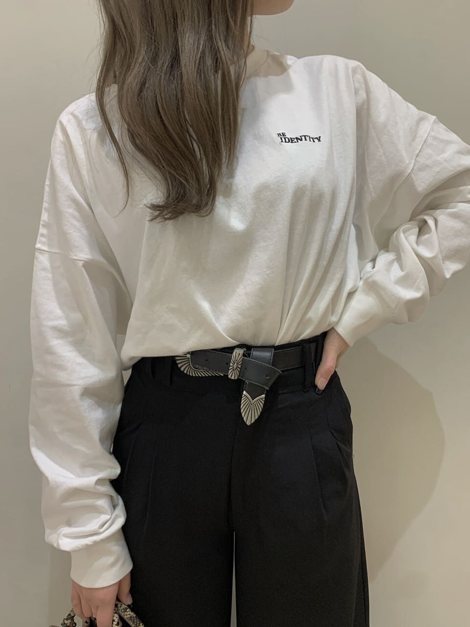 ホワイト系のTシャツ/カットソー、ブラック系のその他パンツ、ベージュ系のショルダーバッグを着用したレディースの秋コーディネートの3枚目の写真