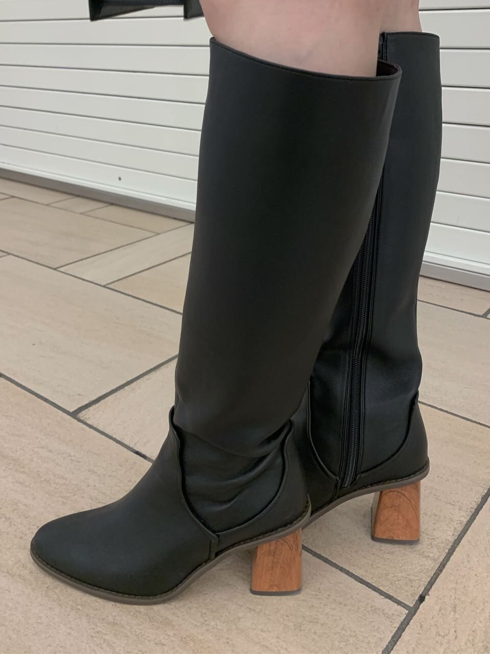 ブラウン系のワンピース、ブラック系のブルゾン、ブラック系のブーツを着用したレディースの秋コーディネートの5枚目の写真