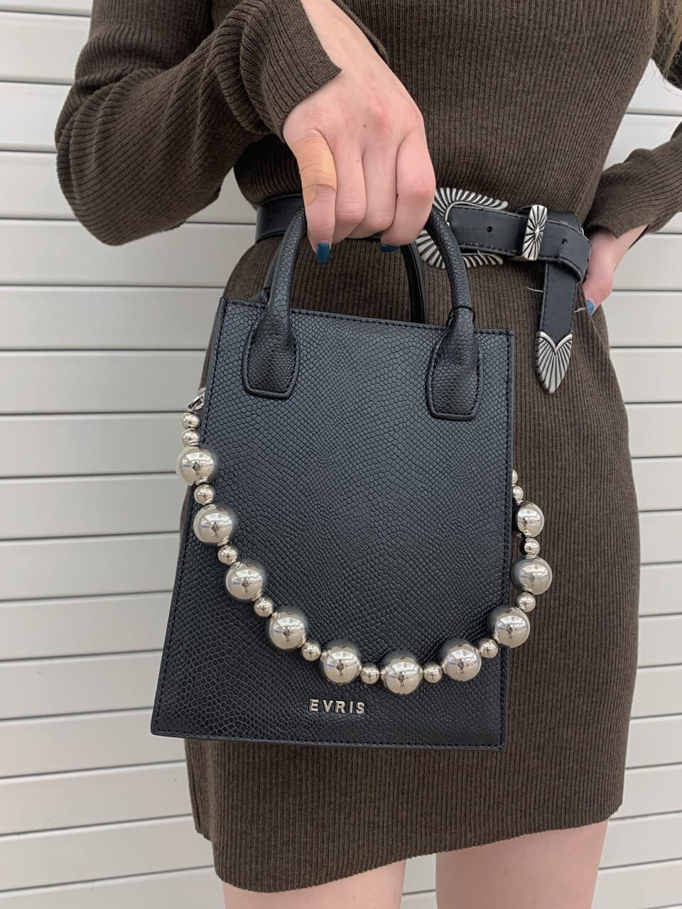 ブラウン系のワンピース、ブラック系のブルゾン、ブラック系のブーツを着用したレディースの秋コーディネートの4枚目の写真