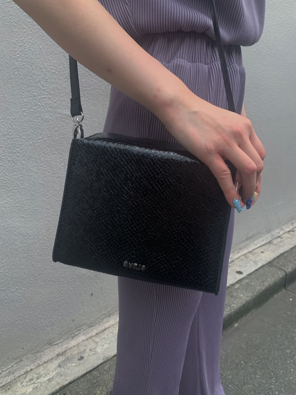 ブラック系のサンダル、パープル系のTシャツ/カットソー、パープル系のスラックスを着用したレディースの夏コーディネートの3枚目の写真