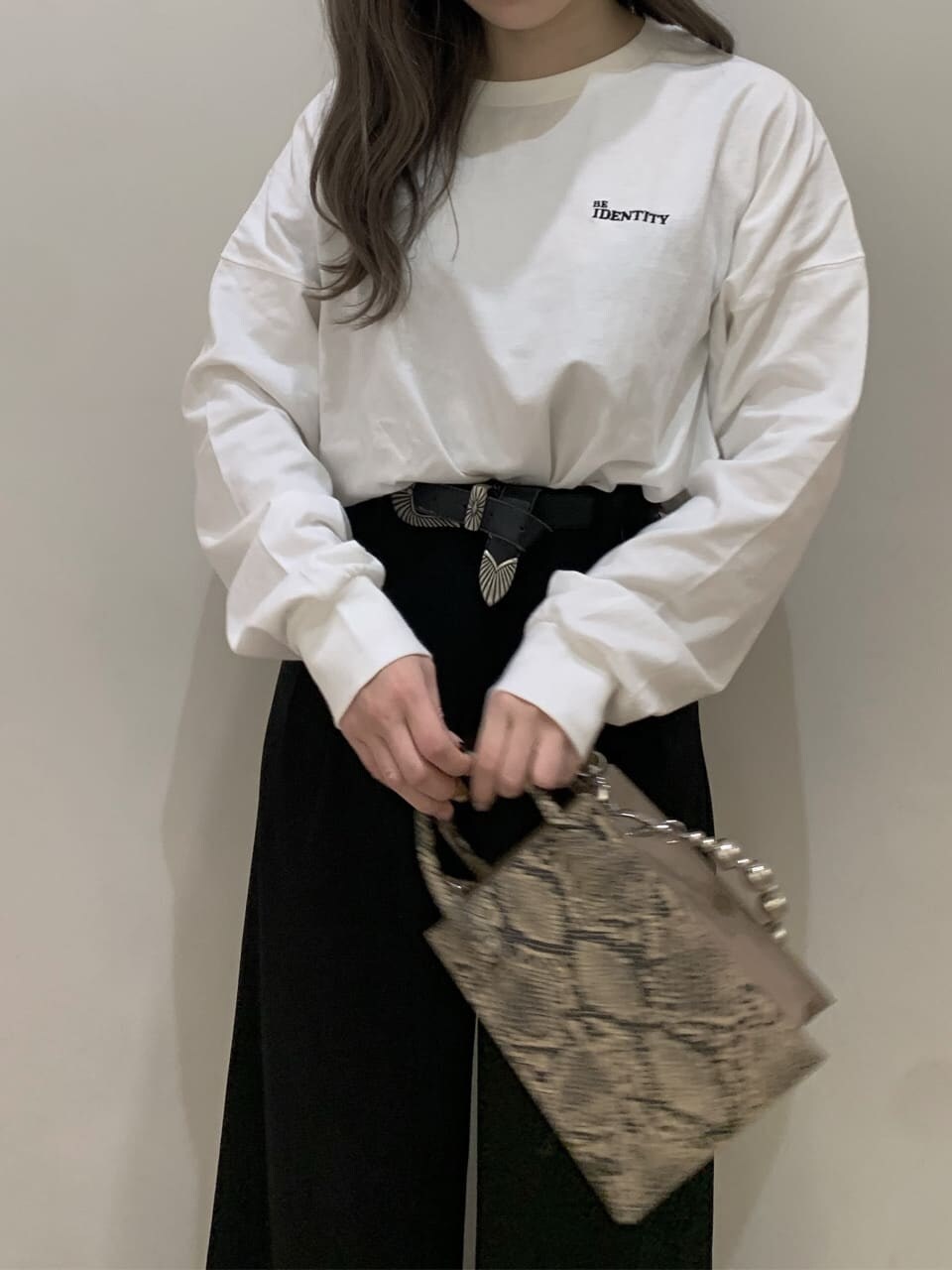 ホワイト系のTシャツ/カットソー、ブラック系のその他パンツ、ベージュ系のショルダーバッグを着用したレディースの秋コーディネートの2枚目の写真