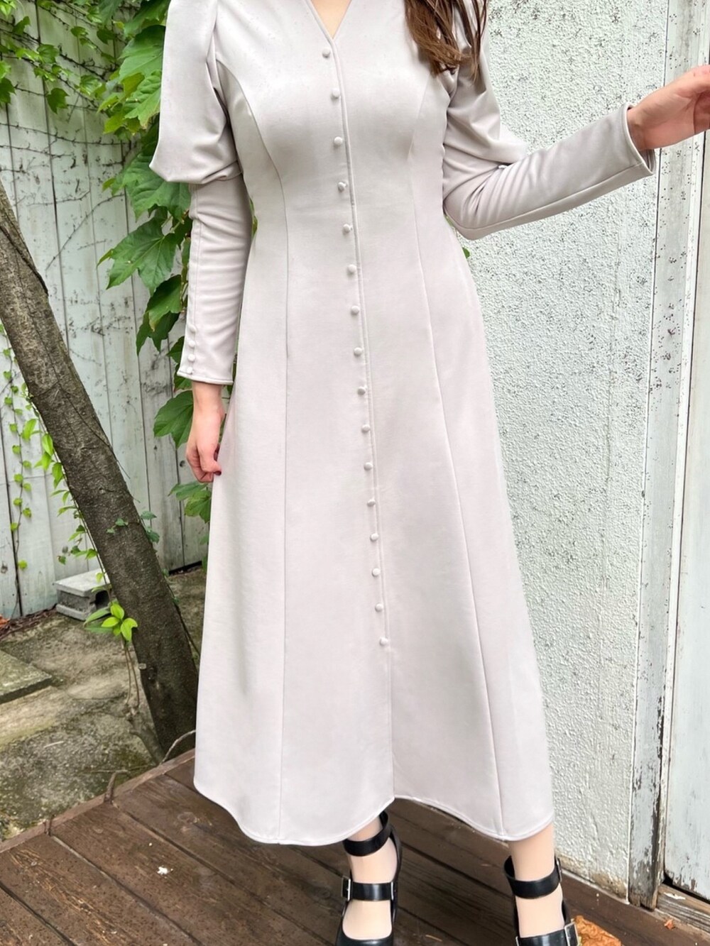 ベージュ系のワンピース、ブラック系のパンプス、ホワイト系のチョーカーを着用したレディースの秋コーディネートの3枚目の写真