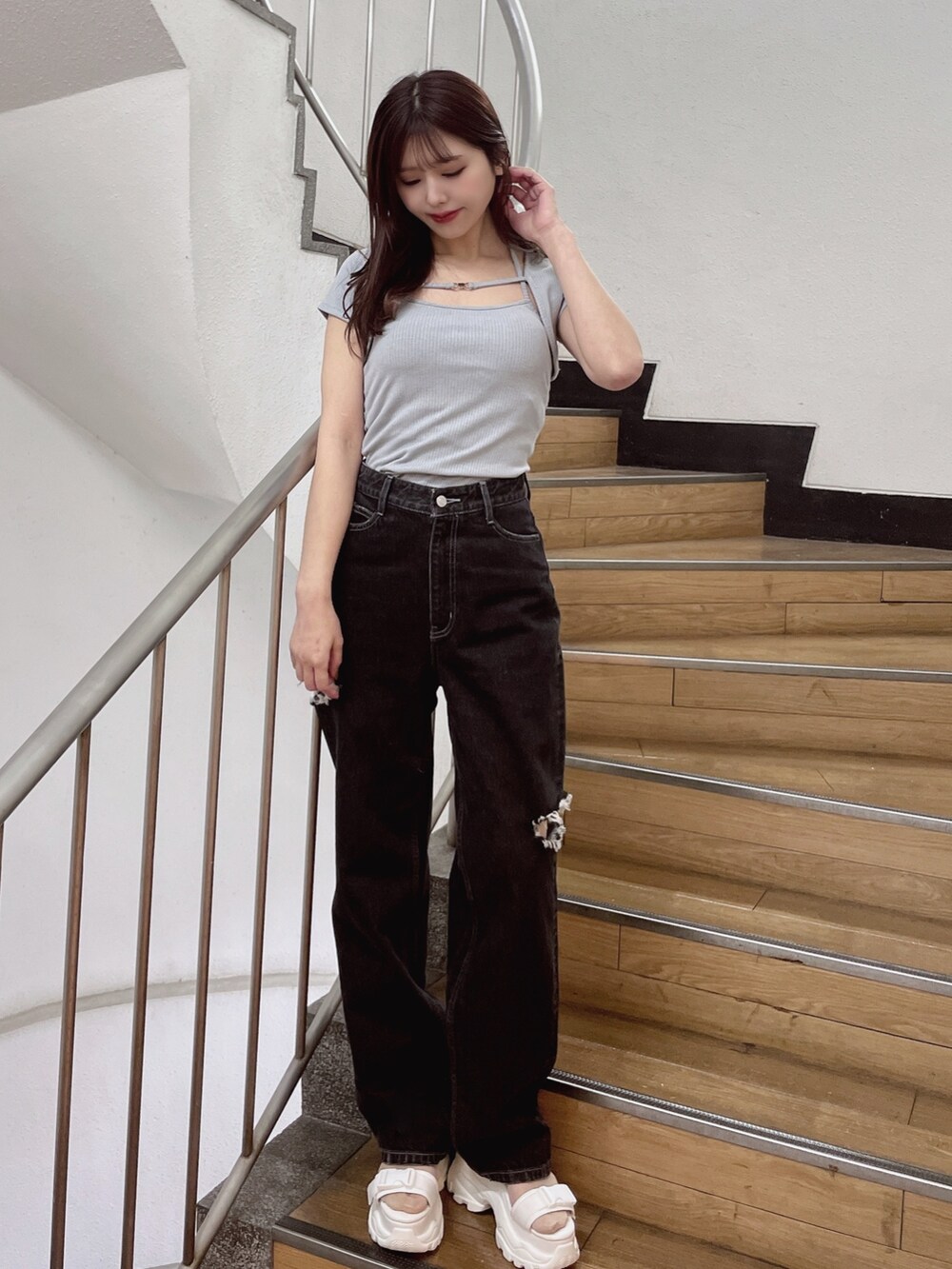 ブルー系のニット/セーター、ブラック系のデニムパンツ、ホワイト系のサンダルを着用したレディースの春コーディネートの2枚目の写真