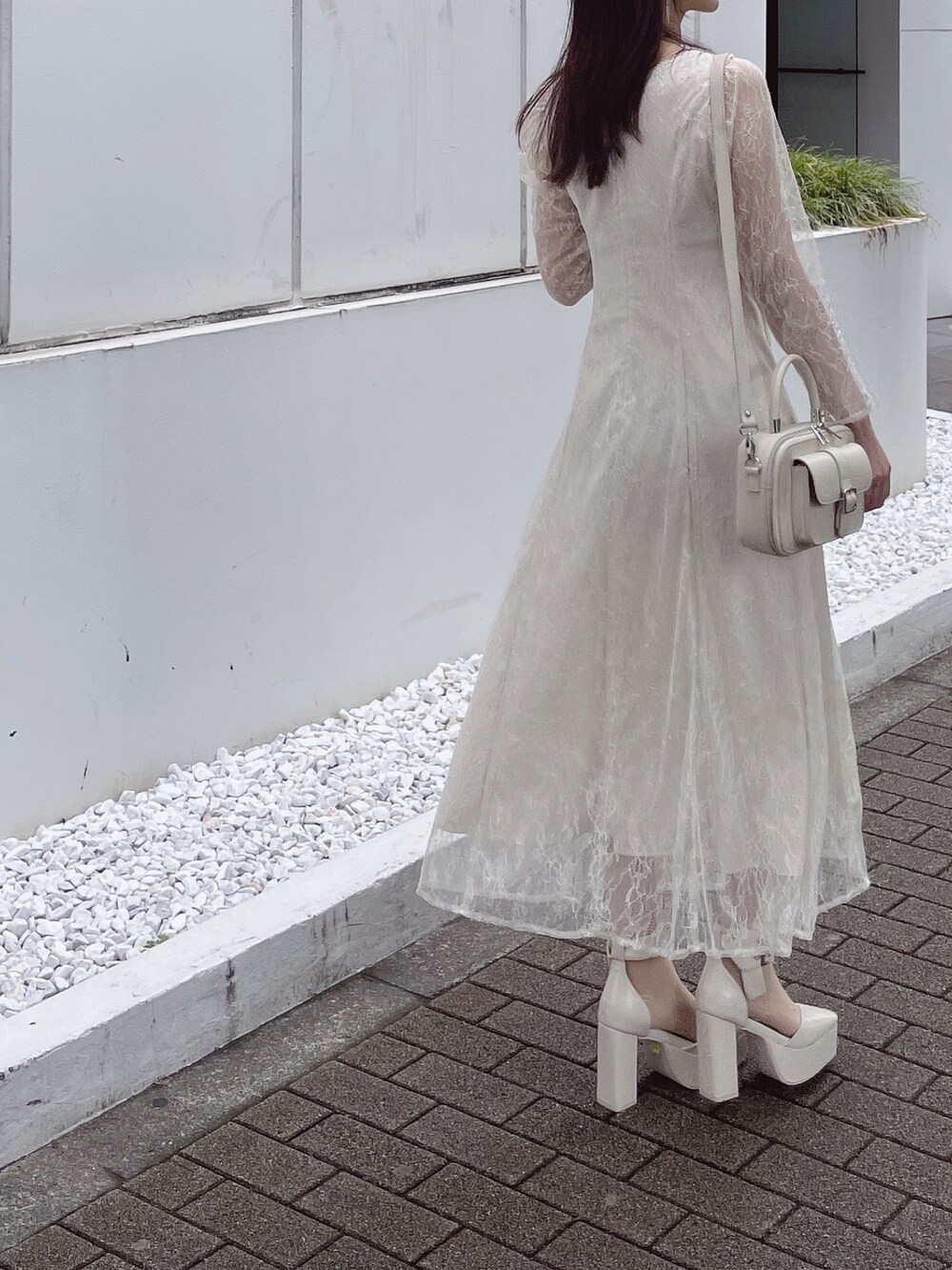 ホワイト系のパンプス、ホワイト系のハンドバッグ、ホワイト系のワンピースを着用したレディースの夏コーディネートの5枚目の写真