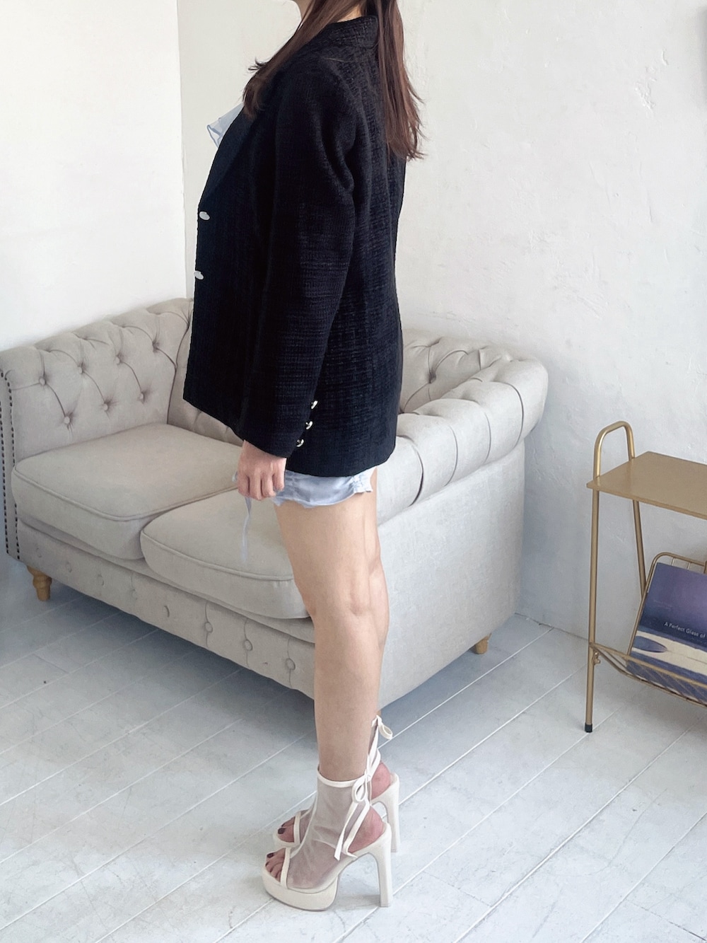 ブルー系のキャミソール、ブラック系のテーラードジャケット、ブルー系のスカートを着用したレディースの春コーディネートの5枚目の写真