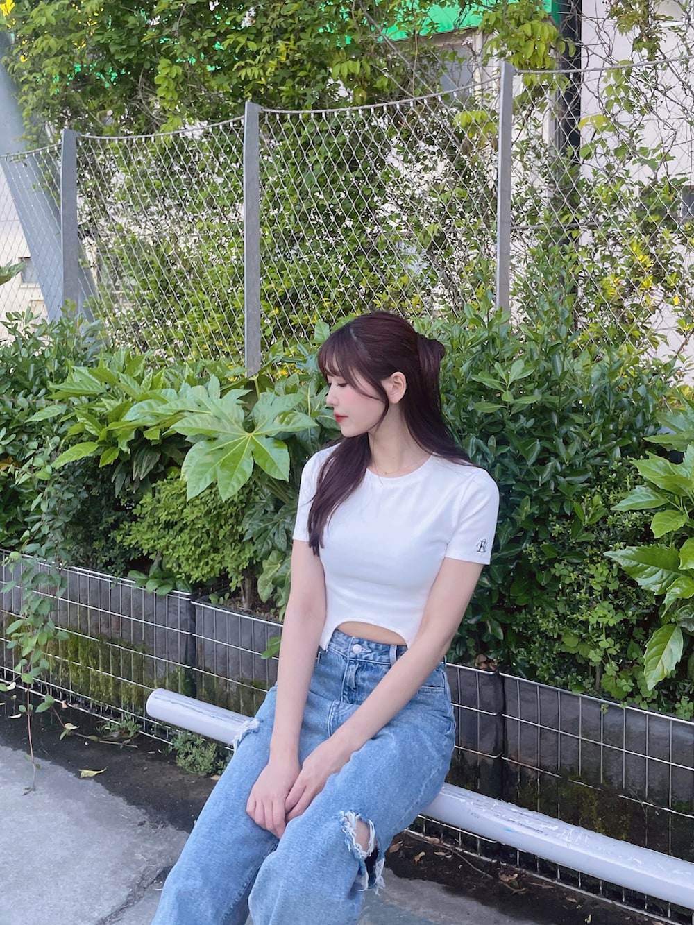 ブルー系のデニムパンツ、ホワイト系のTシャツ/カットソー、ブラック系のショルダーバッグを着用したレディースの春コーディネートの4枚目の写真