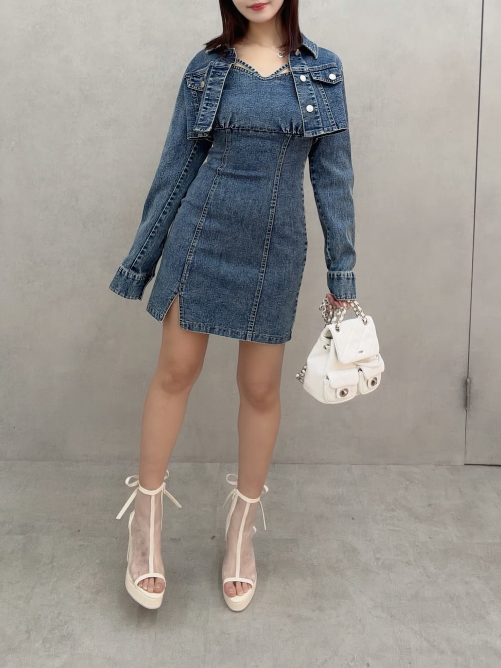 ブルー系のワンピース、ホワイト系のバックパック/リュック、ホワイト系のサンダルを着用したレディースの冬コーディネートの3枚目の写真