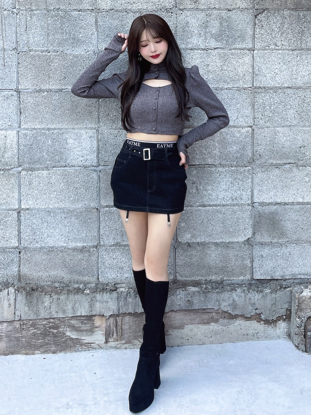 グレー系のTシャツ/カットソー、ブラック系のスカート、ブラック系のブーツを着用したレディースの秋コーディネートの2枚目の写真