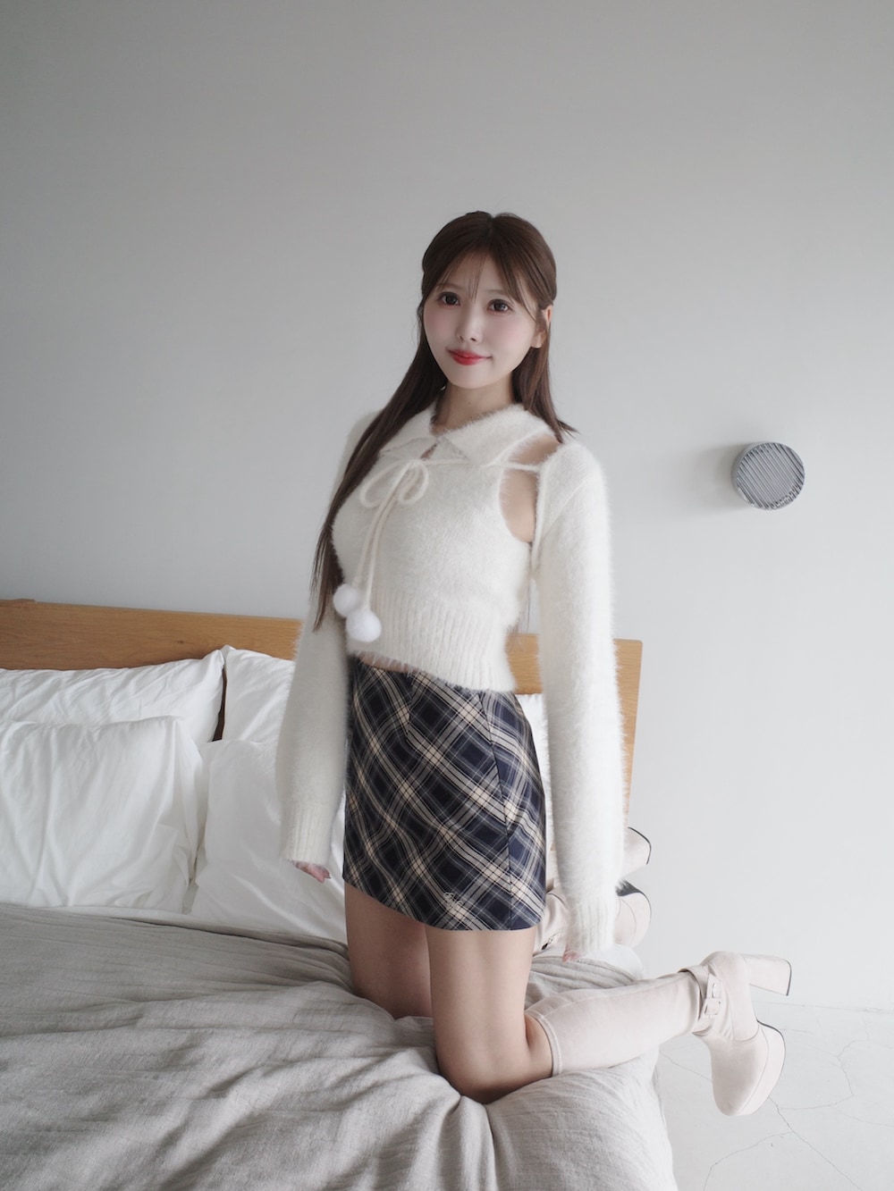 ホワイト系のニット/セーター、ブルー系のスカート、ホワイト系のブーツを着用したレディースの秋コーディネートの4枚目の写真