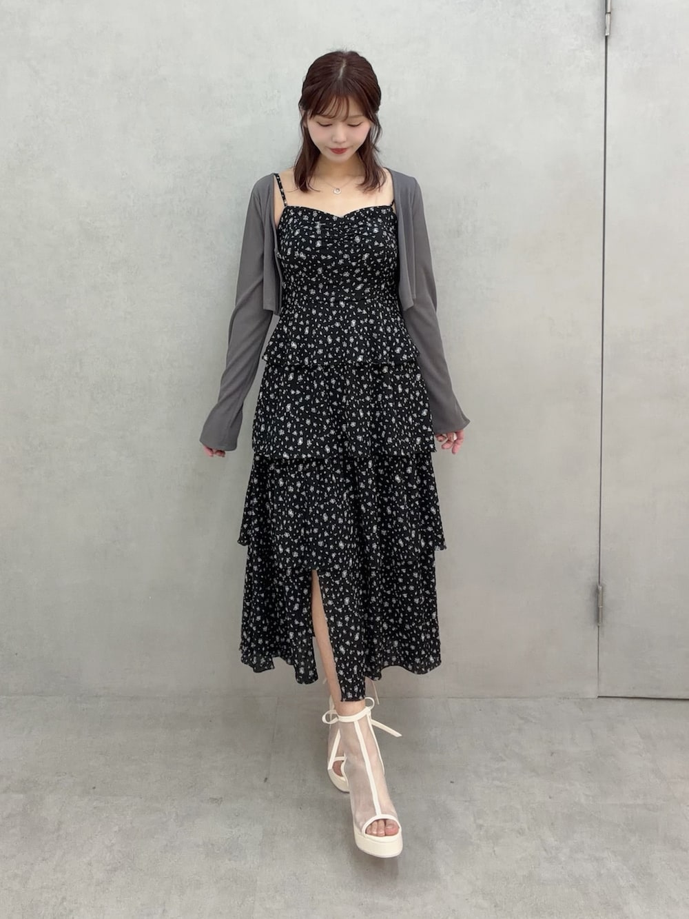 ブラック系のワンピース、ホワイト系のサンダル、グレー系のTシャツ/カットソーを着用したレディースの冬コーディネートの2枚目の写真