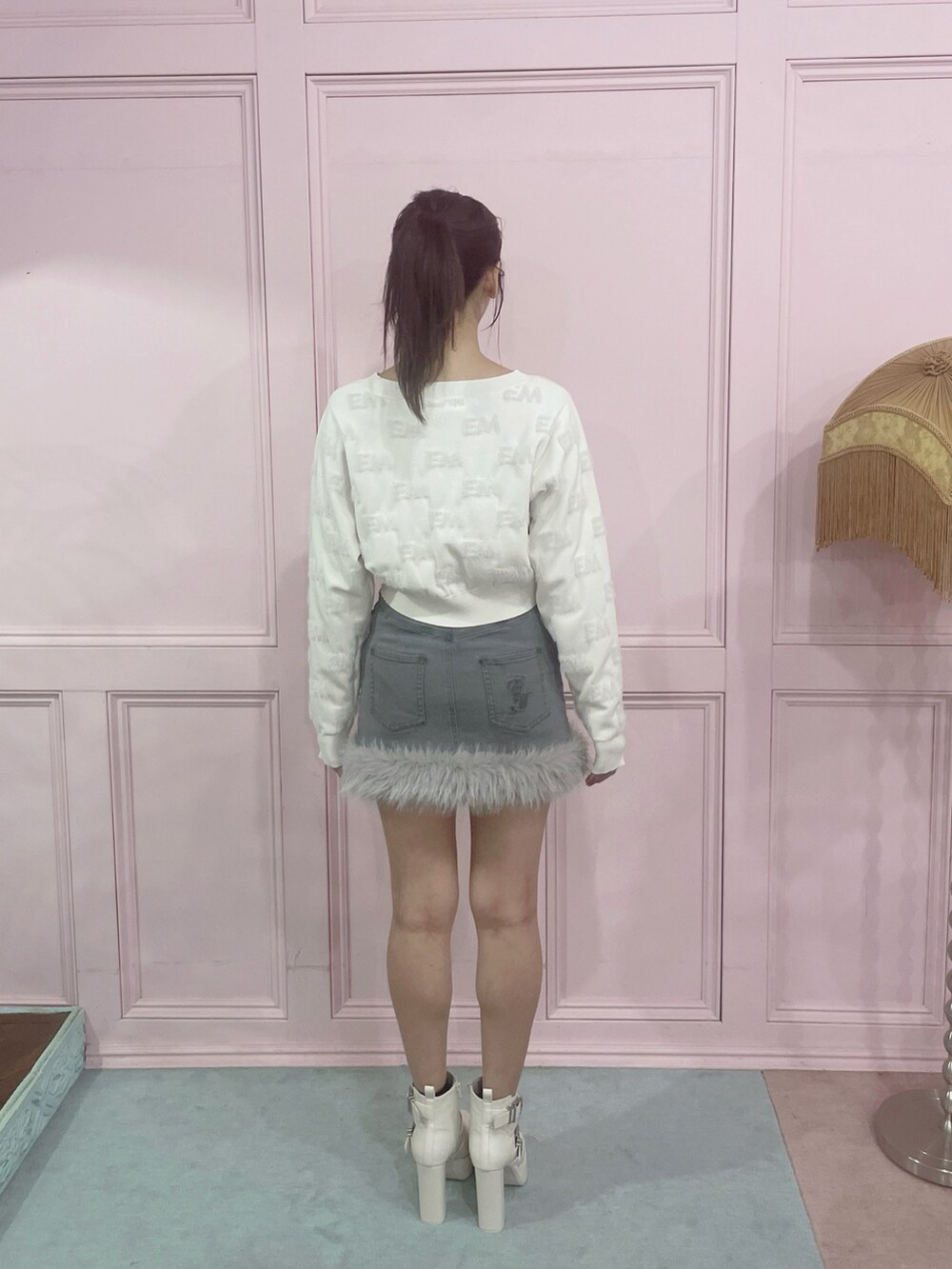 ホワイト系のニット/セーター、グレー系のデニムスカート、ホワイト系のブーツを着用したレディースの秋コーディネートの7枚目の写真