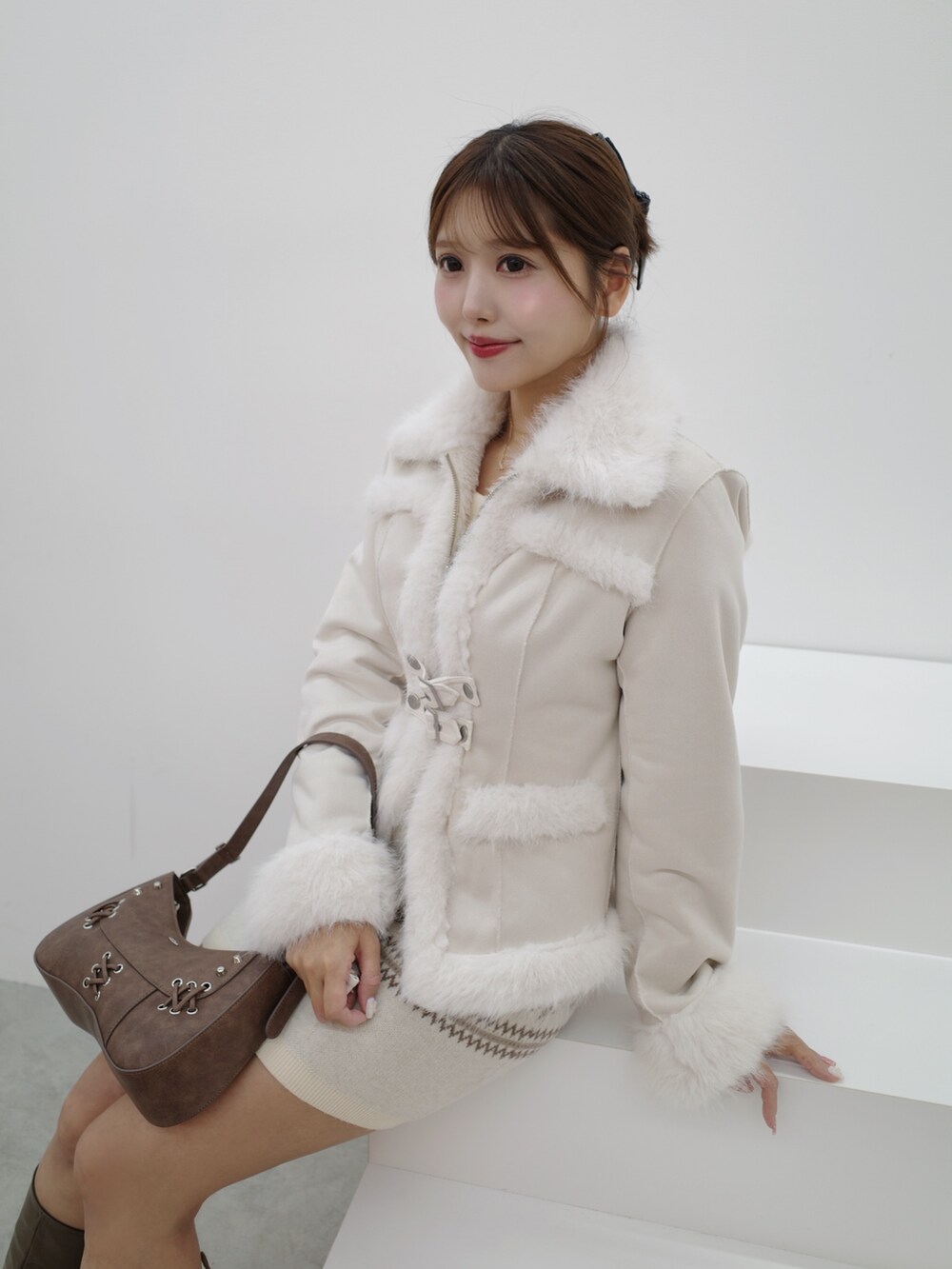 ホワイト系のブルゾン、ホワイト系のスカート、ブラウン系のショルダーバッグを着用したレディースの秋コーディネートの3枚目の写真