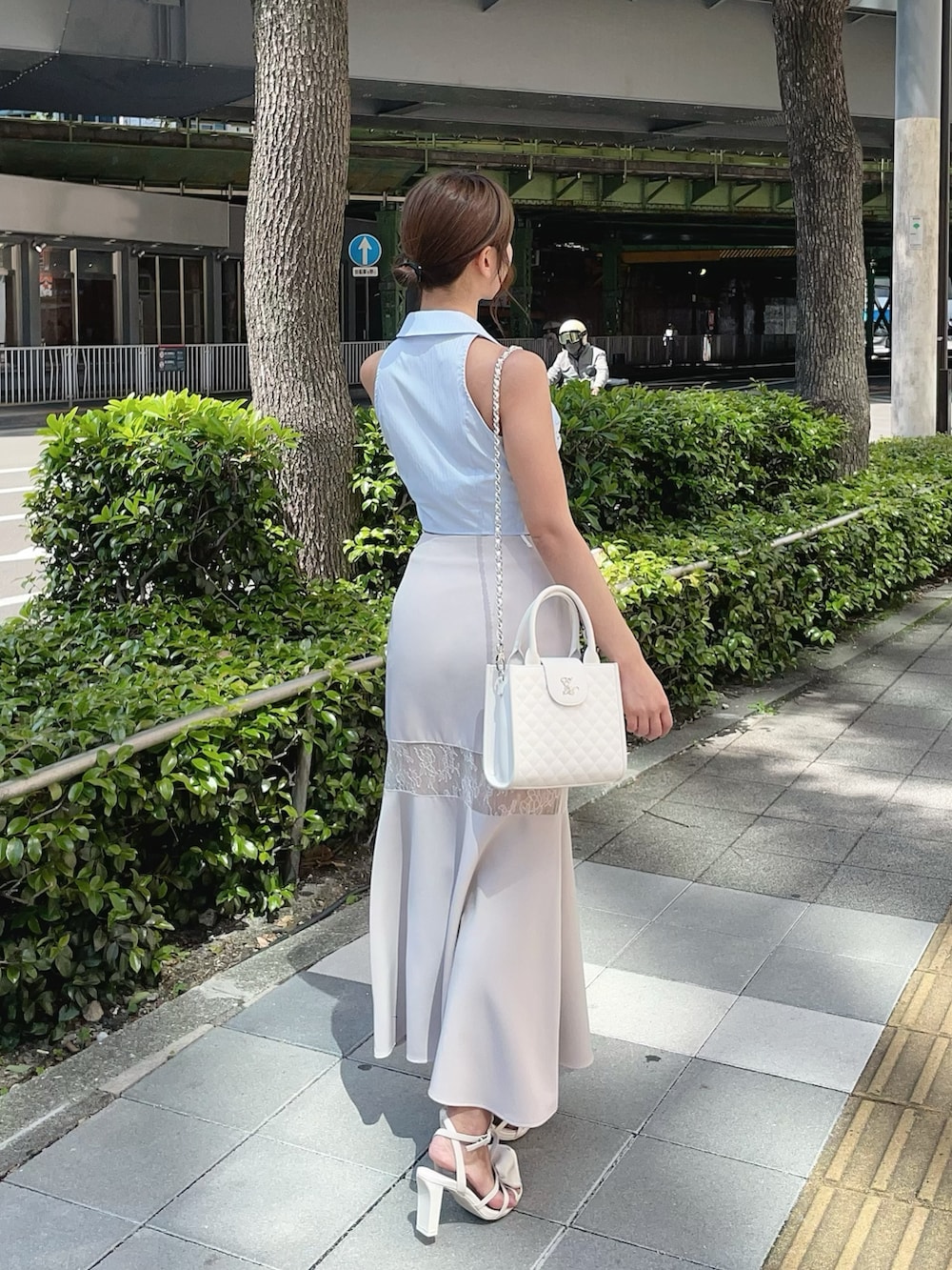 ブルー系のシャツ/ブラウス、ホワイト系のサンダル、ホワイト系のハンドバッグを着用したレディースの夏コーディネートの2枚目の写真
