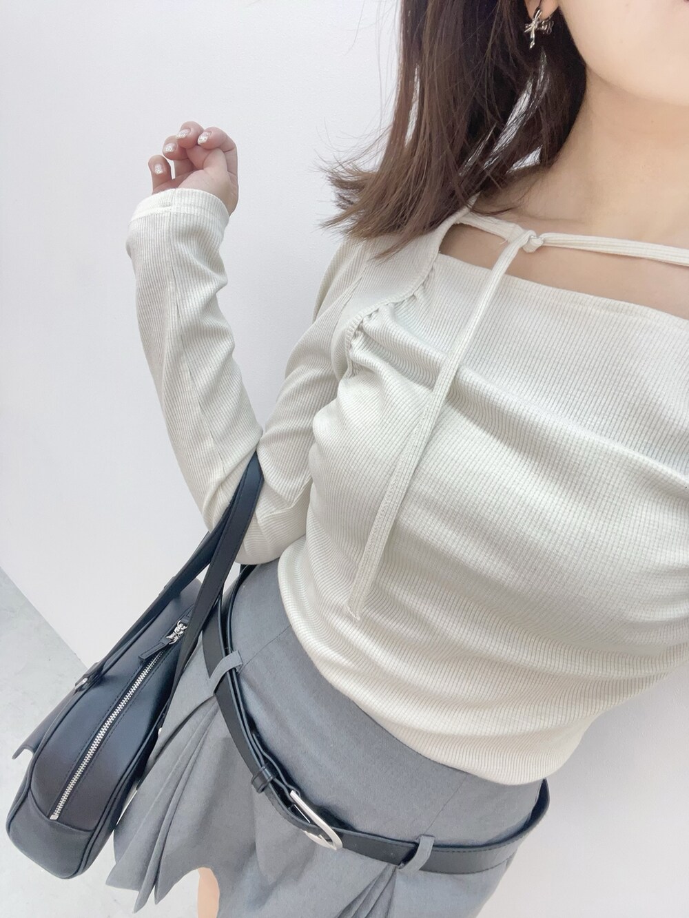 ホワイト系のTシャツ/カットソー、グレー系のスカート、ブラック系のボストンバッグを着用したレディースの春コーディネートの6枚目の写真