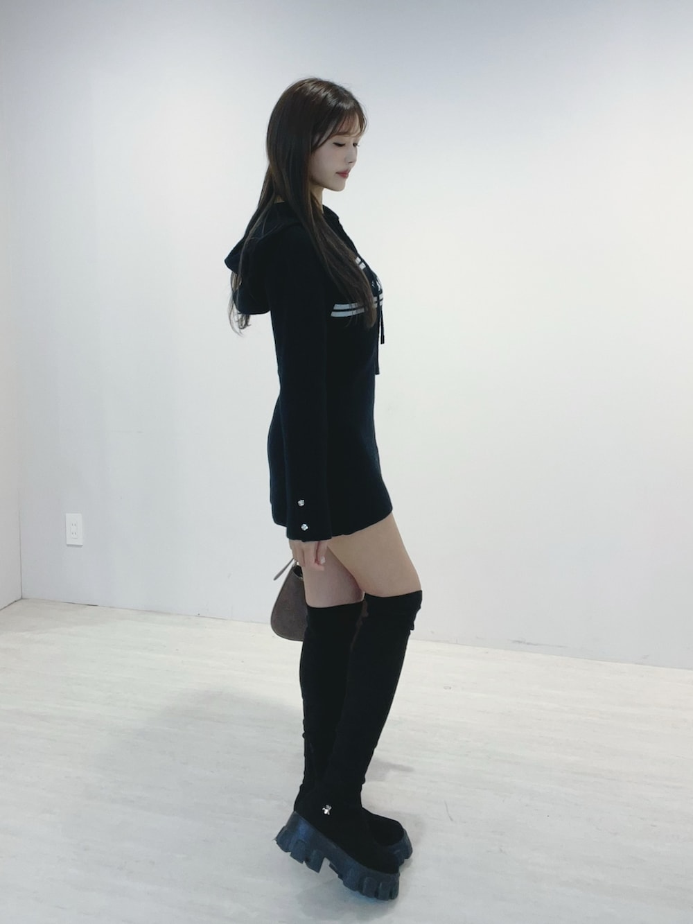 ブラック系のワンピース、ブラック系のブーツ、ブラウン系のショルダーバッグを着用したレディースの秋コーディネートの3枚目の写真