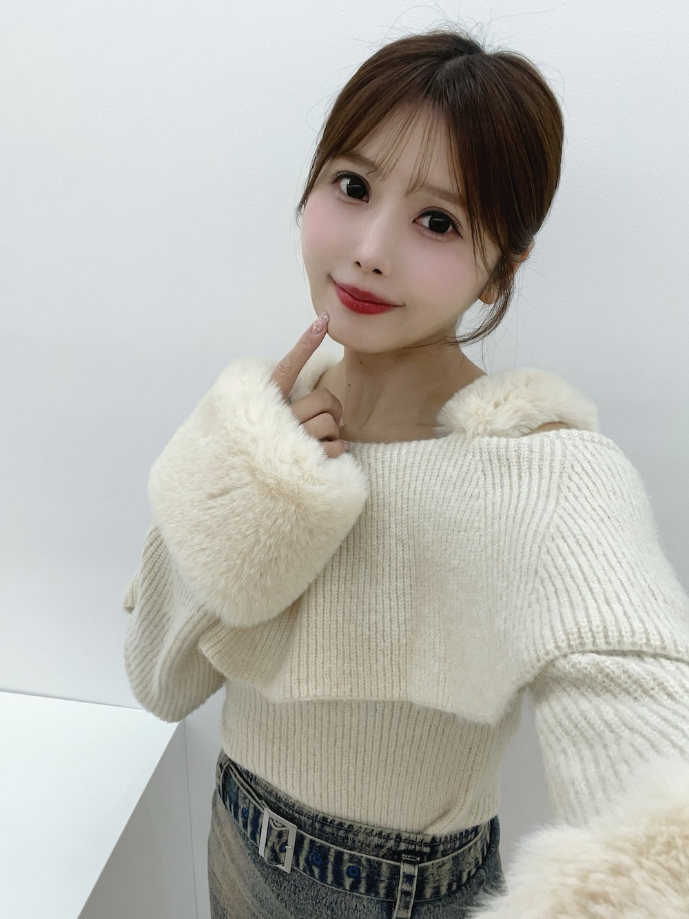 ホワイト系のニット/セーター、ブルー系のデニムスカート、ブラック系のブーツを着用したレディースの秋コーディネートの10枚目の写真