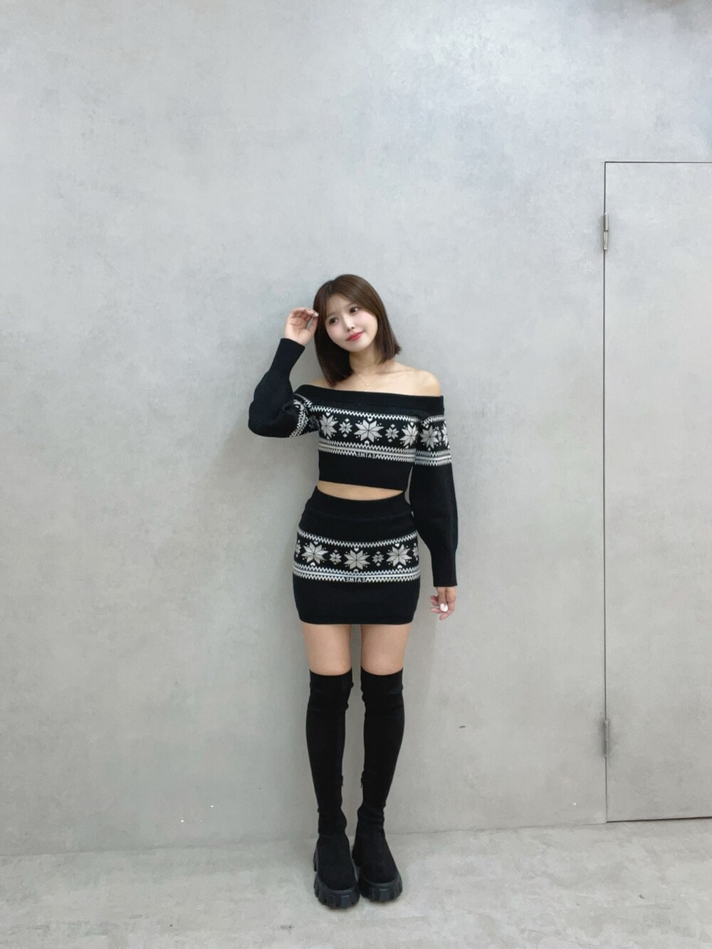 ブラック系のニット/セーター、ブラック系のスカート、ブラック系のブーツを着用したレディースの秋コーディネートの2枚目の写真