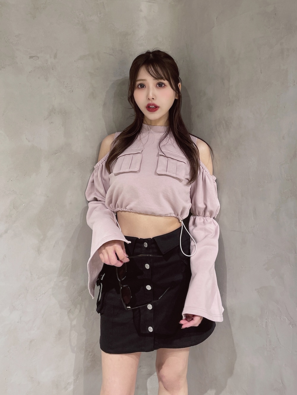 ピンク系のスウェット、ブラック系のスカートを着用したレディースの冬コーディネートの2枚目の写真