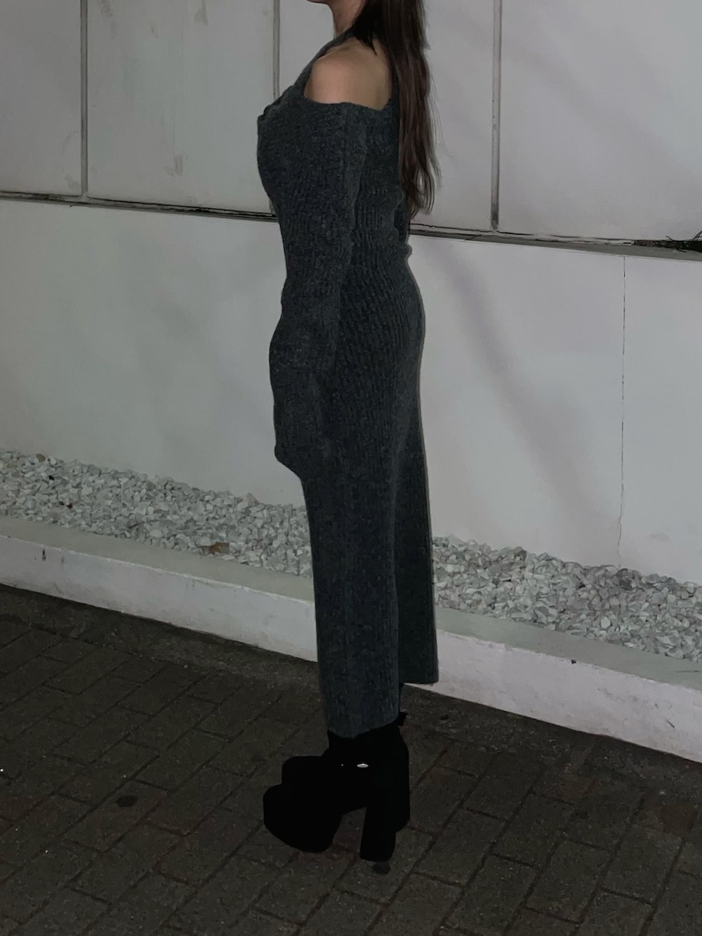 グレー系のワンピース、ブラック系のハンドバッグ、ブラック系のブーツを着用したレディースの冬コーディネートの5枚目の写真