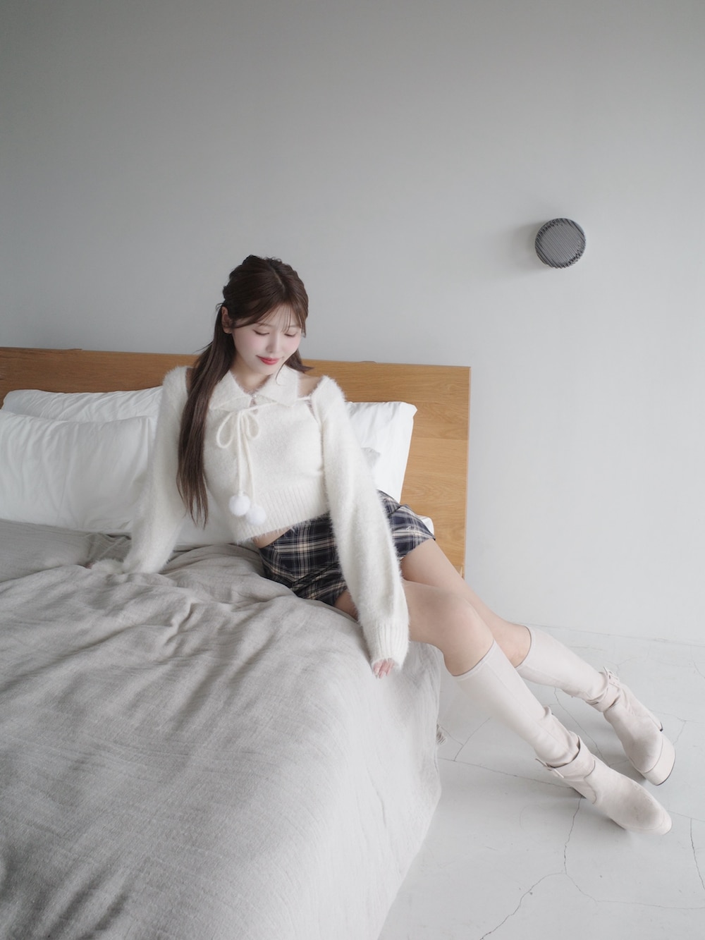 ホワイト系のニット/セーター、ブルー系のスカート、ホワイト系のブーツを着用したレディースの秋コーディネートの6枚目の写真