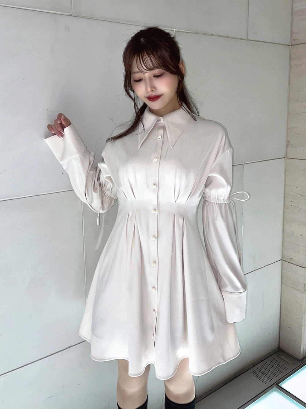 ホワイト系のワンピース、ブラック系のブーツを着用したレディースの冬コーディネートの3枚目の写真