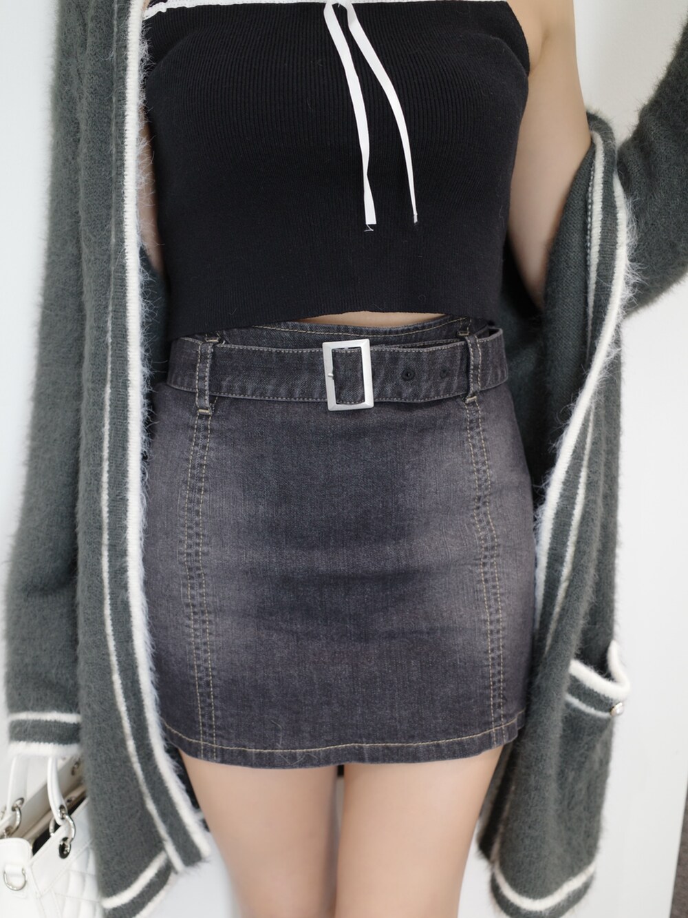 ブラック系のニット/セーター、グレー系のワンピース、ブルー系のデニムスカートを着用したレディースの秋コーディネートの9枚目の写真