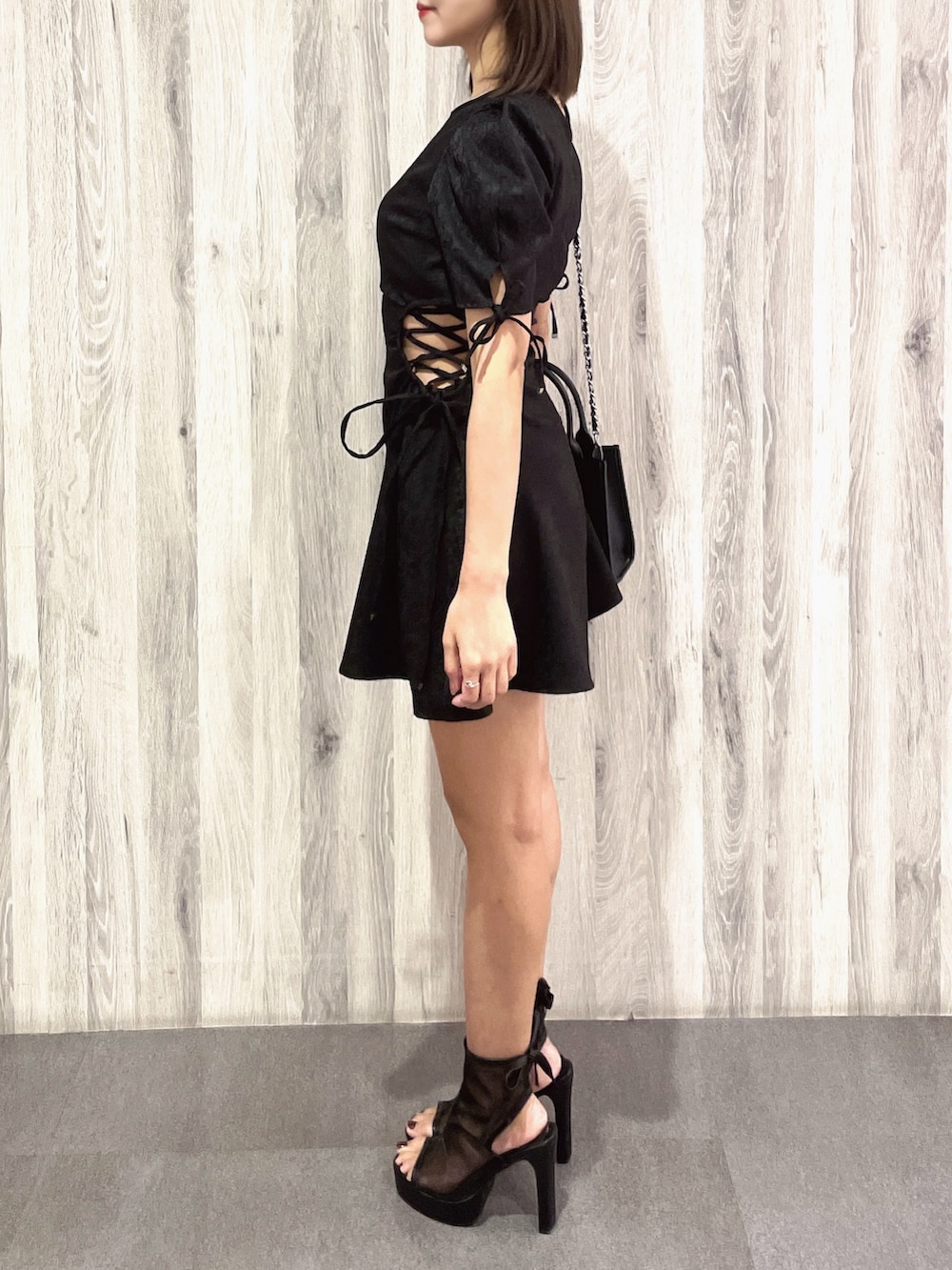 ブラック系のサンダル、ブラック系のハンドバッグ、ブラック系のワンピースを着用したレディースの春コーディネートの3枚目の写真