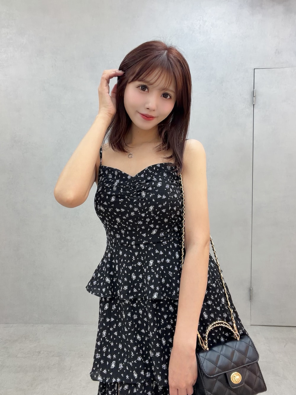 ホワイト系のサンダル、ブラック系のワンピース、ブラック系のハンドバッグを着用したレディースの冬コーディネートの7枚目の写真