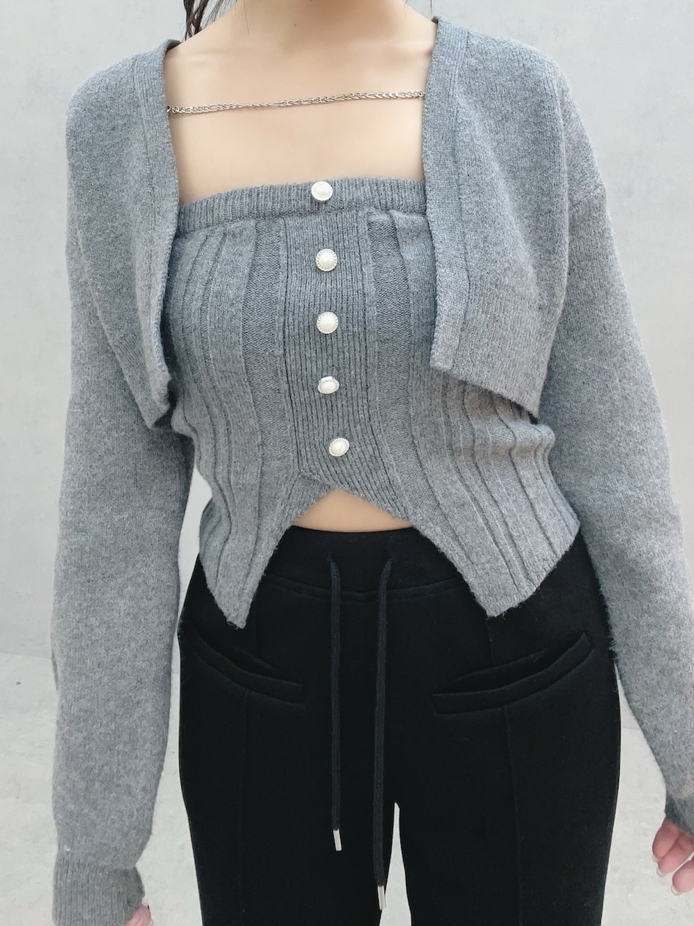 グレー系のニット/セーター、ブラック系のその他パンツ、ホワイト系のバックパック/リュックを着用したレディースの冬コーディネートの6枚目の写真