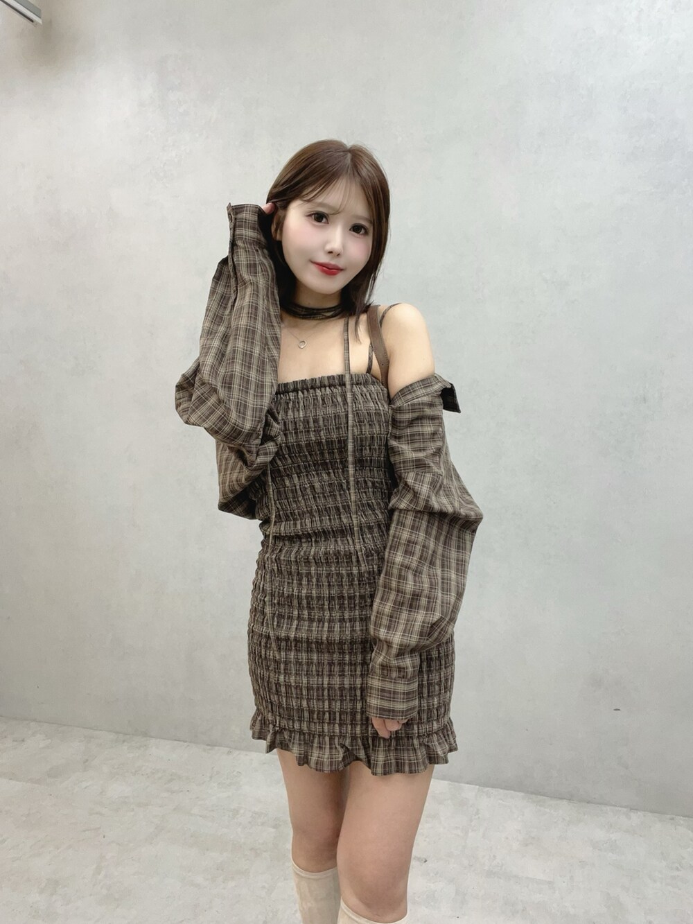 ブラウン系のワンピース、ブラウン系のショルダーバッグ、ホワイト系のブーツを着用したレディースの秋コーディネートの6枚目の写真