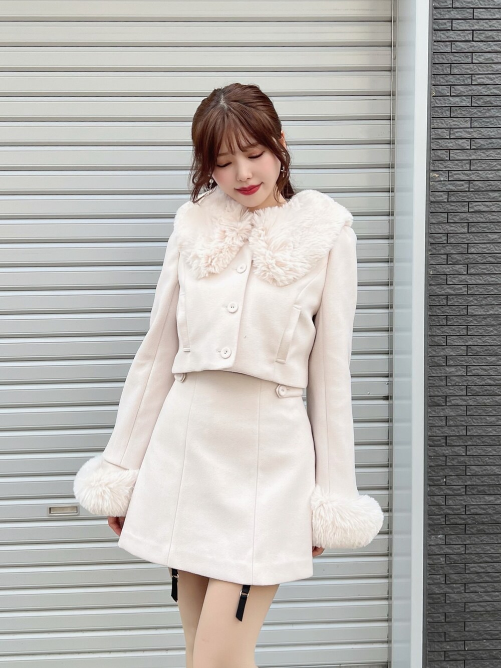 ホワイト系のセットアップ、ホワイト系のスカート、ブラック系のブーツを着用したレディースの秋コーディネートの5枚目の写真